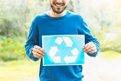 Person holding recycle sign in countryside