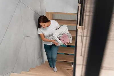 Woman carrying a bunch of dirty clothes in the basket