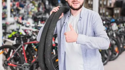Man with bicycle tires gesturing thumb up