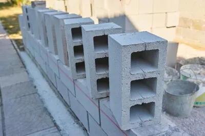 Worker builds a cinder block wall for a new home