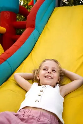 High angle smiley girl laying in bounce house