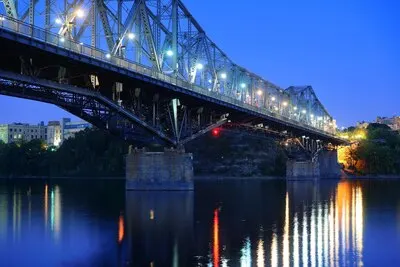 Ottawa at night over river with historical architecture.