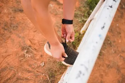 Sporty woman tying shoes on stadium track