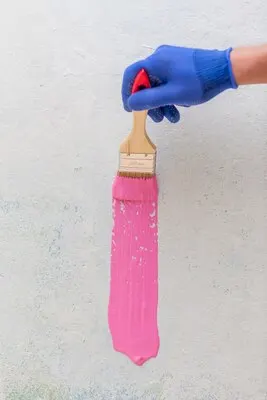 Top view of hand holding a brush with pink paint