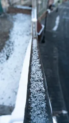 Vertical selective focus shot of snow in a railing in a Sibiu, Romania