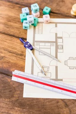 Close-up of divider, ruler, math blocks and blueprint on wooden desk