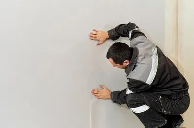 Wall repairman is finishing wallpapering on the left there is a place for an inscription Wallpapering at home home restoration concept