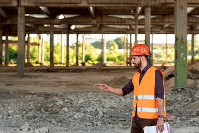 Side view man with orange vest pointing