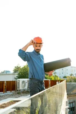 Architect holding blueprint with protective helmet
