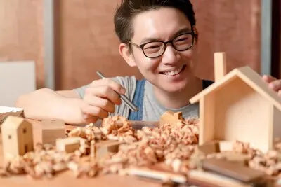 Smart attractive handy glasses asian male craftman or interior designer focus wood working at site constrution home interior design renovation and improvement concept
