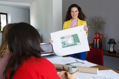 Smiling architect showing house design to clients or colleagues