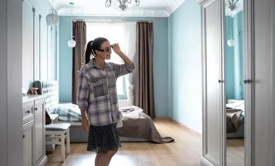 Stylish young woman in front of a mirror in the room gathering