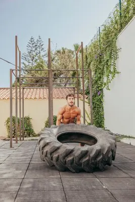 Strong man lifting tractor wheel