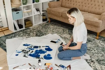 Beautiful young woman artist drawing in a comfy home interior