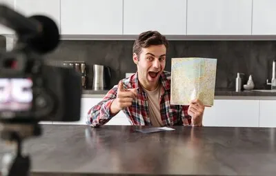 Cheerful young man filming his video blog episode