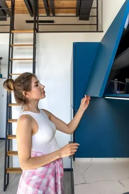 Woman opens cabinet kitchen organization stylish home