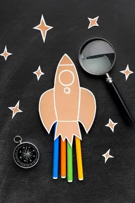 Back to school rocket with magnifying glass and pencils