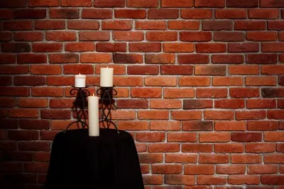 Candles on table over brick wall