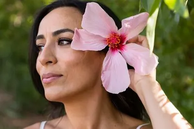 Side view of beautiful woman outdoors with flower in hair