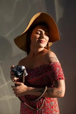 Medium shot woman holding photo camera