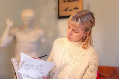 Young attractive female artist reading an anatomy book Learning concept