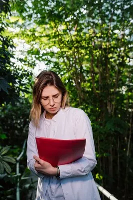 Young female agricultural engineer working in greenhouse