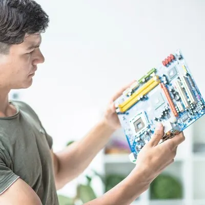 Young man looking at motherboard circuit