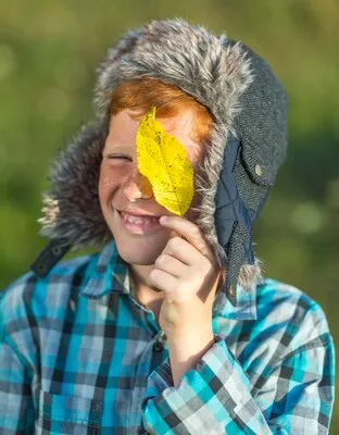 Portrait of young boy holding a yellow leave