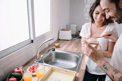Man making toast with butter for woman