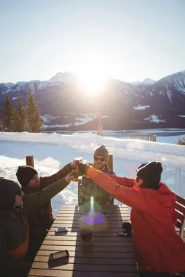 Skiers friends toasting glasses of beer in ski resort