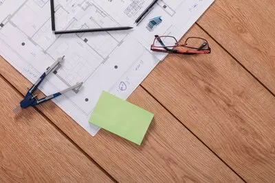 Compasses and sticky notes near glasses and drafts
