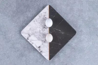 Two colored plate of uncooked fresh eggs on stone.
