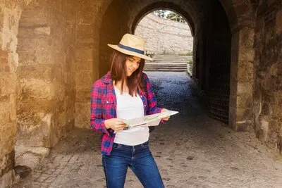 Woman wearing hat looking at direction in map