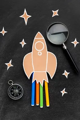 Back to school rocket with magnifying glass and pencils