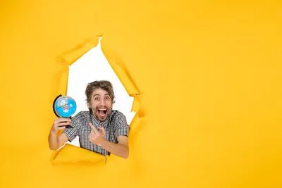 Front view young male holding earth globe on a yellow background emotion planet christmas holiday country world color