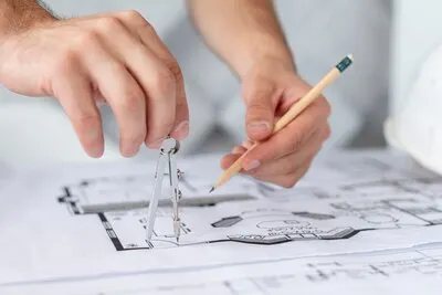 Close-up architect using a compass and a pencil