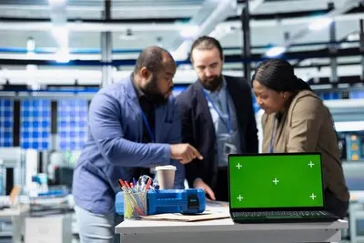 Coworkers brainstorming solutions with mockup display in solar plant
