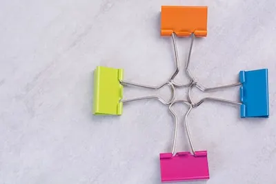 Four paper clips on white surface.