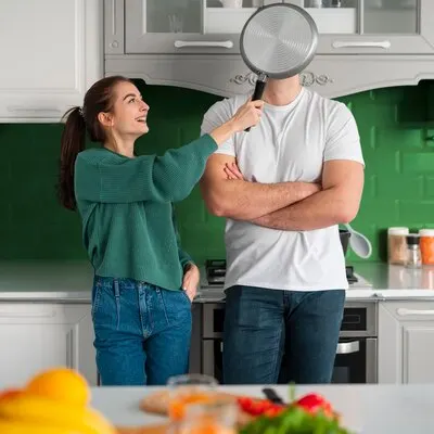 Couple with sieve in a green kitchen