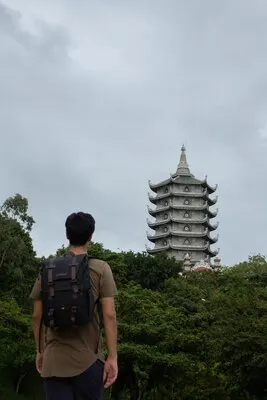 Vertical shot of a male tourist looking to the Pagoda temple, Marble mountains, Vietnam