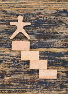 Marketing concept with wooden figure and blocks on wooden background flat lay.