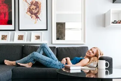 Cheerful woman lying and relaxing on sofa at home