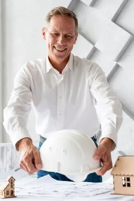 Architect putting safety helmet on desk