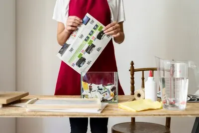 Midsection view of a woman holding paper behind wooden desk