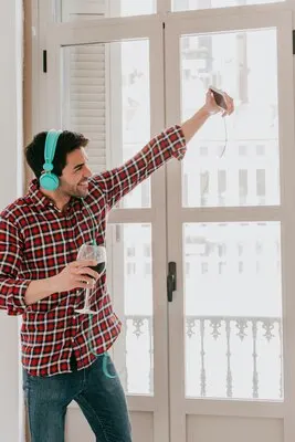 Cheerful man taking selfie with wine