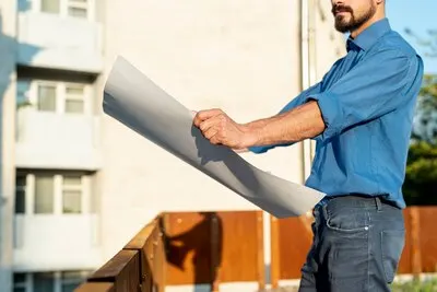 Side view of man holding schematics