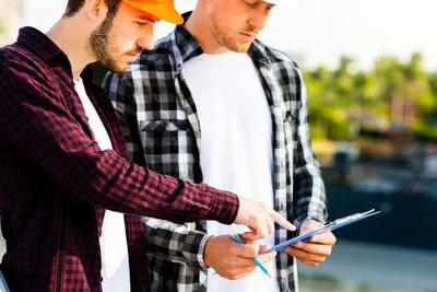Close-up of engineer and architect  looking at clipboard