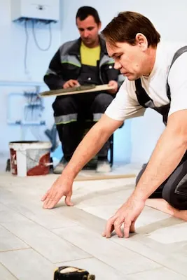 Installing ceramic floor tiles in construction site construction workers Workers laying tiles on the floor with cement adhesive Renovating the floor Vertical frame