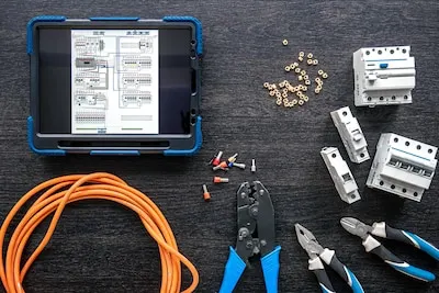 Different electrical tools and digital tablet on wooden background flat lay