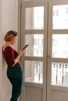 Beautiful woman using tablet near window